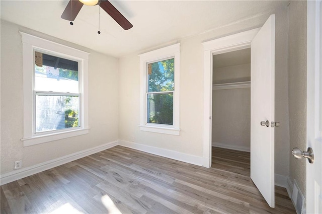 unfurnished bedroom featuring a closet, visible vents, baseboards, and wood finished floors