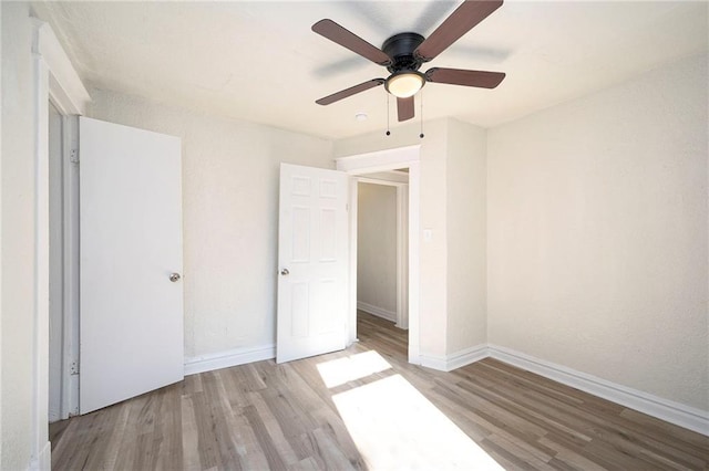 unfurnished bedroom with a ceiling fan, baseboards, and wood finished floors