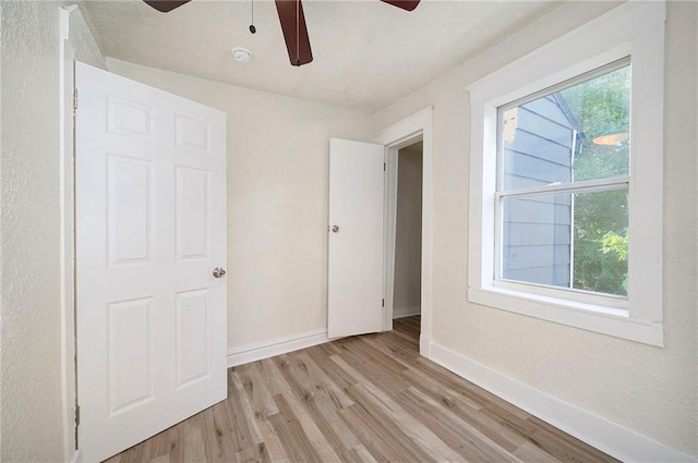 unfurnished bedroom featuring light wood-style floors, a ceiling fan, and baseboards