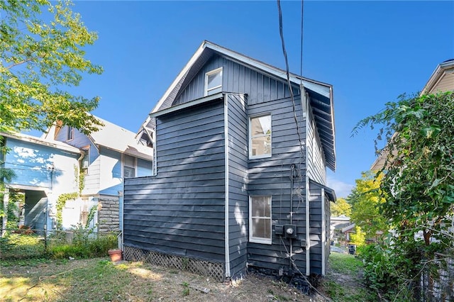 rear view of property featuring fence and board and batten siding