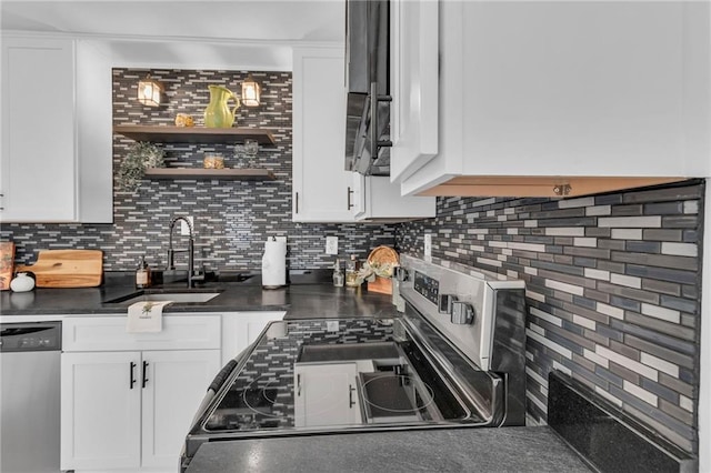 kitchen featuring dark countertops, white cabinets, stainless steel appliances, and a sink