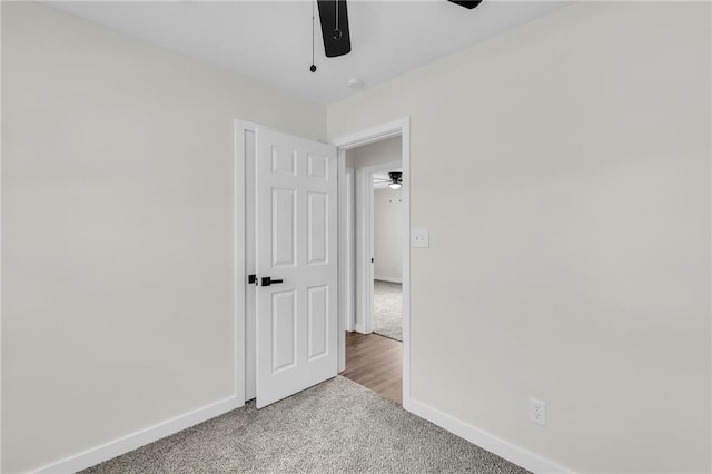 unfurnished bedroom featuring a ceiling fan, baseboards, and carpet flooring