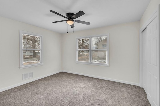 unfurnished bedroom featuring carpet, a closet, visible vents, and baseboards