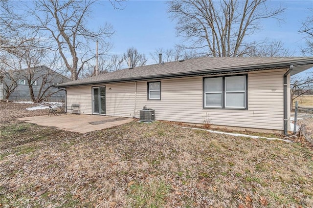 rear view of house with central AC unit, roof with shingles, a patio area, and fence