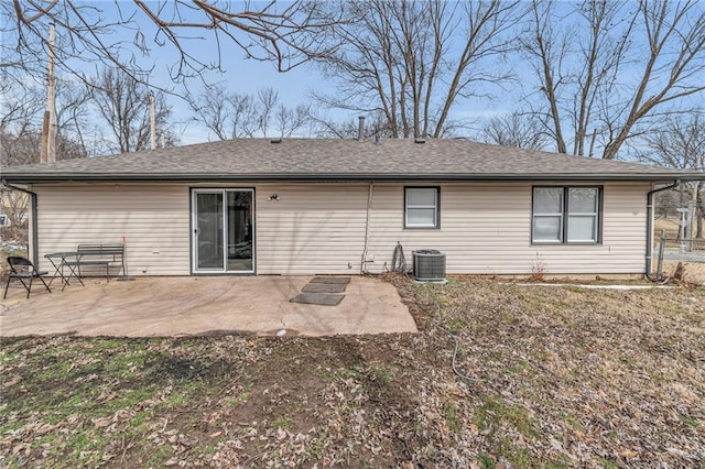 rear view of house with a shingled roof, fence, central AC unit, and a patio