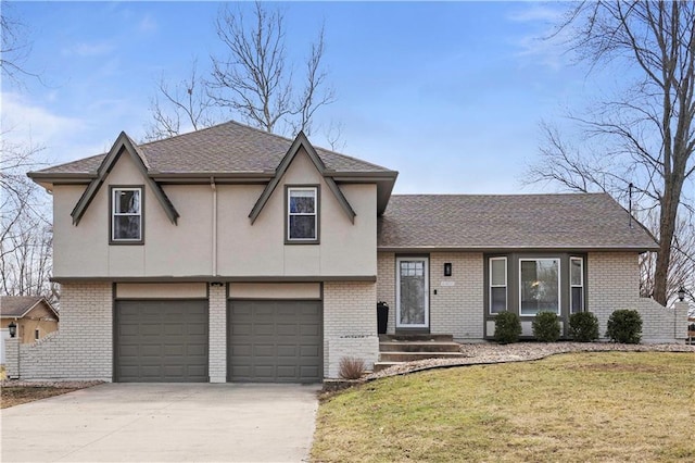 split level home featuring brick siding, a shingled roof, an attached garage, a front yard, and driveway