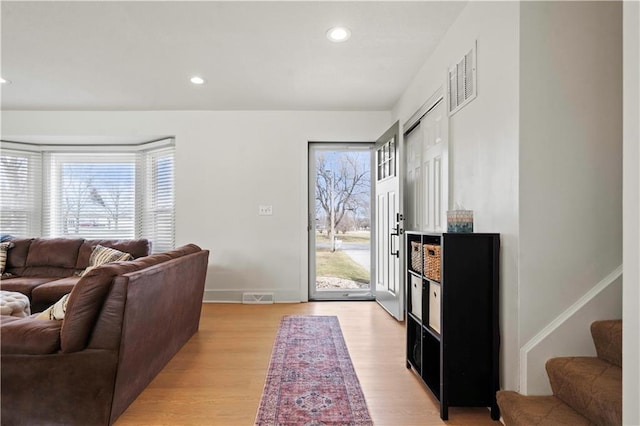 interior space featuring light wood-style floors, recessed lighting, visible vents, and stairway