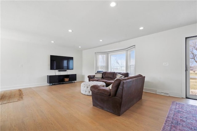 living area with light wood-style floors, baseboards, visible vents, and recessed lighting