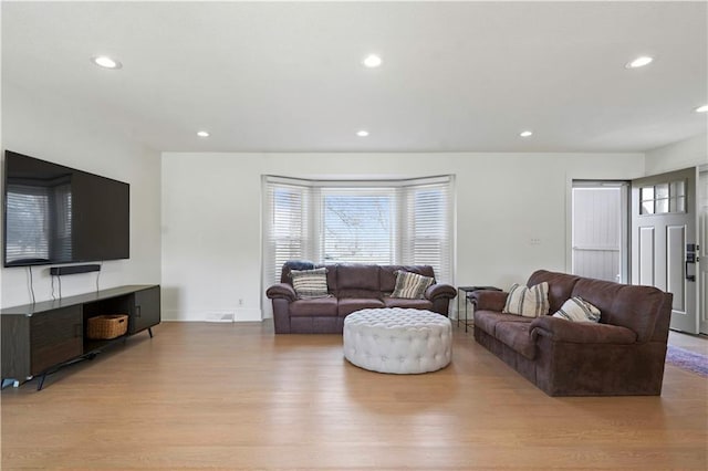 living room featuring baseboards, wood finished floors, and recessed lighting