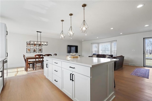 kitchen with light countertops, light wood-type flooring, and a wealth of natural light