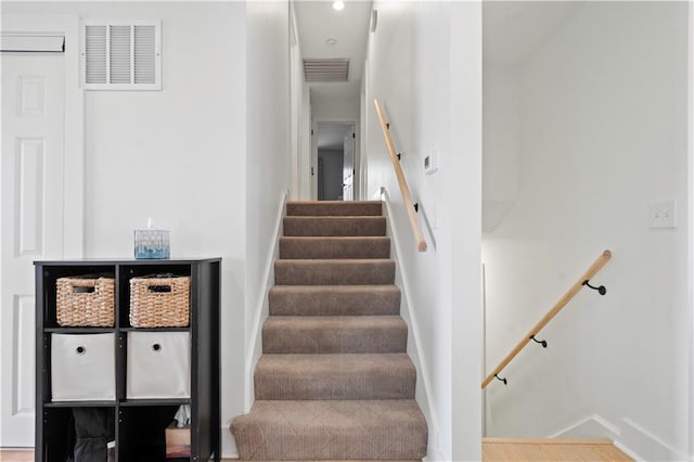 staircase with visible vents and baseboards