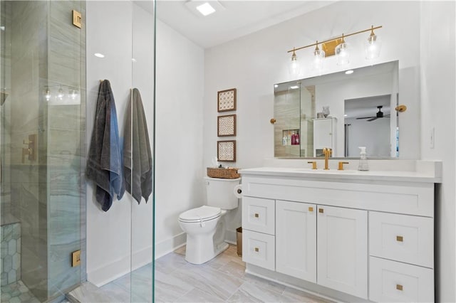 bathroom featuring toilet, a ceiling fan, a shower stall, vanity, and baseboards