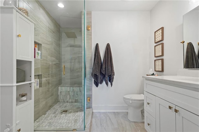 full bathroom with baseboards, a shower stall, toilet, and vanity