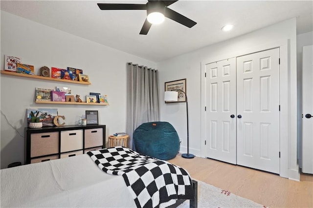 bedroom featuring ceiling fan, a closet, and wood finished floors