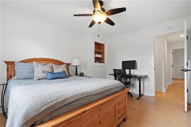 bedroom with light wood-type flooring, a ceiling fan, and baseboards