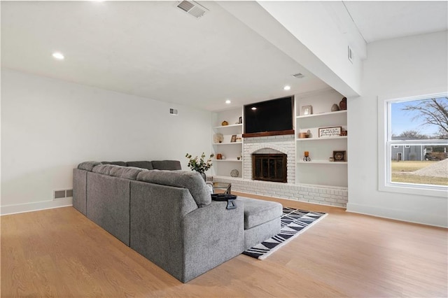 living area featuring visible vents, baseboards, and wood finished floors