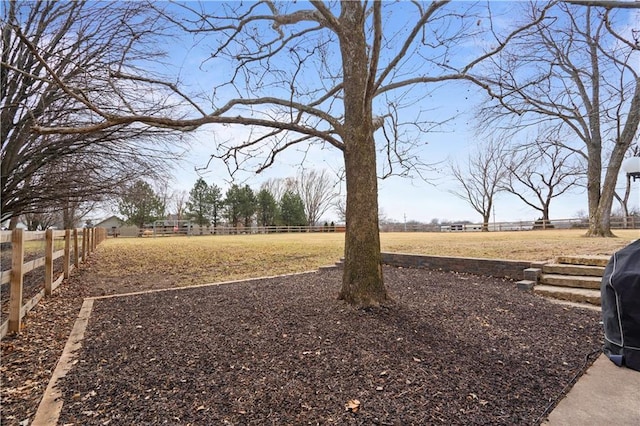 view of yard with a rural view and fence