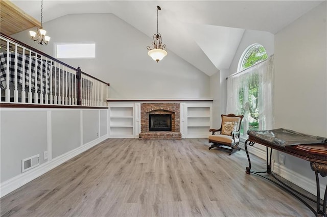 14953 W 124th Ter, Olathe, KS 66062 - living area featuring a chandelier, wood finished floors, a fireplace, high vaulted ceiling, and baseboards