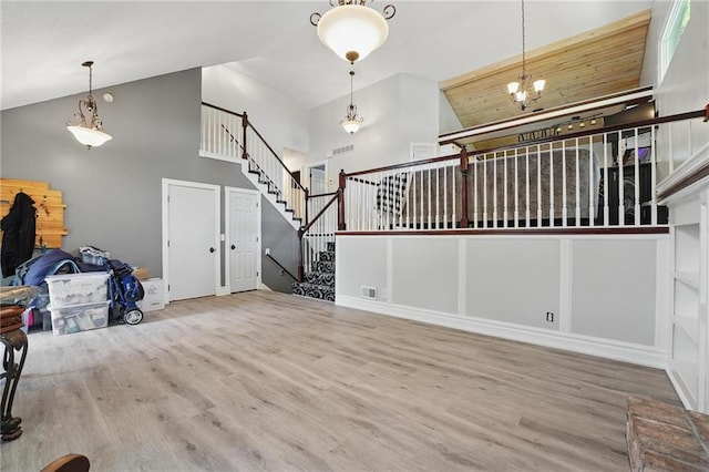 14953 W 124th Ter, Olathe, KS 66062 - unfurnished living room with high vaulted ceiling, wood finished floors, stairs, and a chandelier