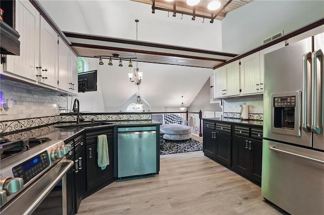 14953 W 124th Ter, Olathe, KS 66062 - kitchen featuring appliances with stainless steel finishes, dark countertops, a sink, tasteful backsplash, and vaulted ceiling
