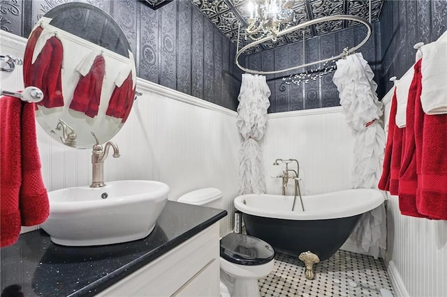 14953 W 124th Ter, Olathe, KS 66062 - bathroom with wallpapered walls, a wainscoted wall, a freestanding bath, a chandelier, and toilet