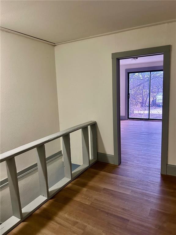 corridor with dark wood-style floors and baseboards