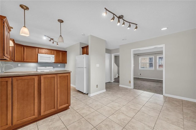 kitchen featuring hanging light fixtures, white appliances, light tile patterned floors, and brown cabinets