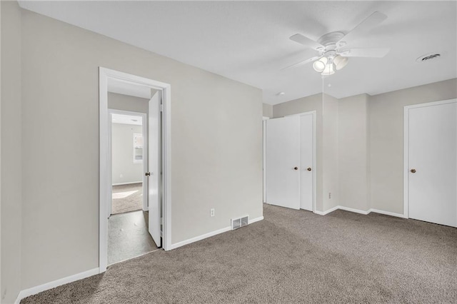 unfurnished bedroom with carpet floors, baseboards, and visible vents