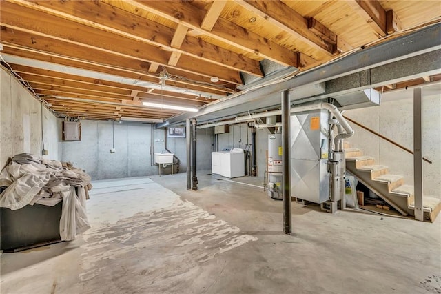 unfinished basement featuring a sink, washer and dryer, water heater, stairs, and heating unit