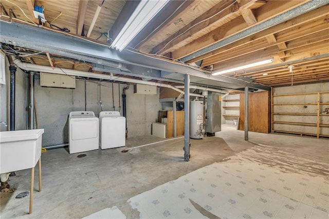 unfinished basement featuring a sink, gas water heater, and independent washer and dryer