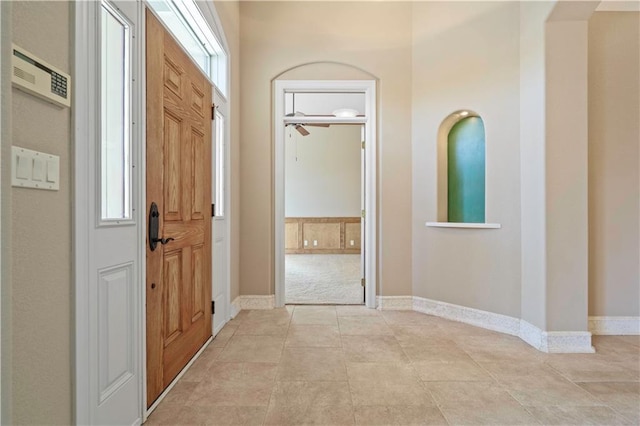 foyer with baseboards and light tile patterned flooring