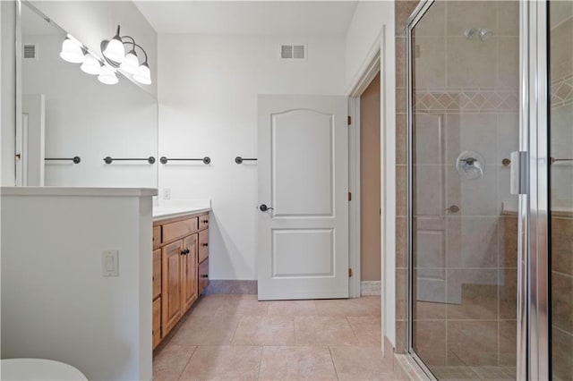 bathroom with vanity, tile patterned flooring, a shower stall, and visible vents