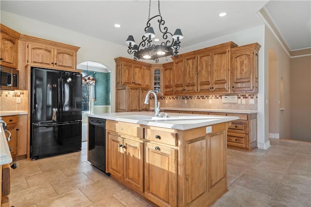 kitchen featuring black appliances, arched walkways, and light countertops