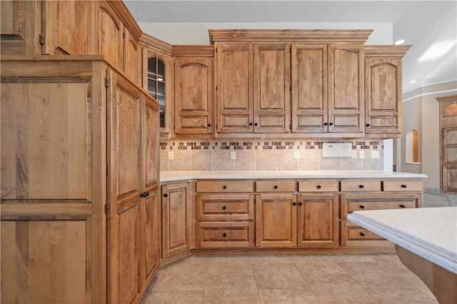 kitchen featuring light countertops, tasteful backsplash, and brown cabinets