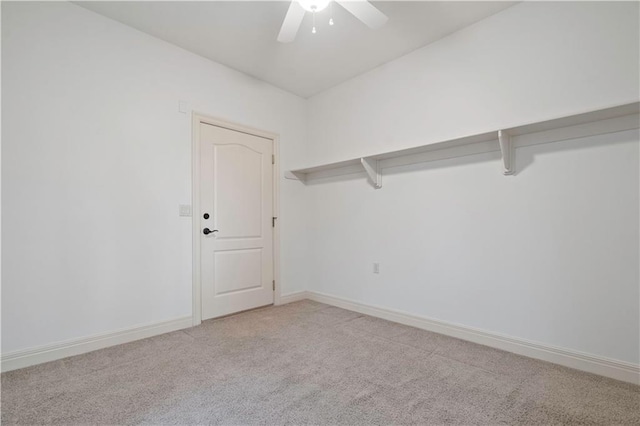 spare room featuring baseboards, a ceiling fan, and light colored carpet