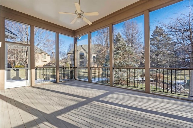 unfurnished sunroom featuring a ceiling fan