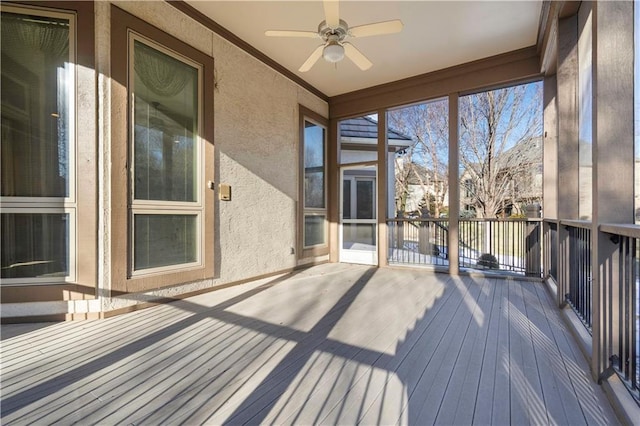 unfurnished sunroom featuring ceiling fan