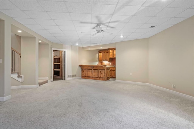 unfurnished living room with visible vents, light colored carpet, stairway, and baseboards