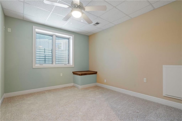 carpeted spare room with a ceiling fan, baseboards, visible vents, and a drop ceiling