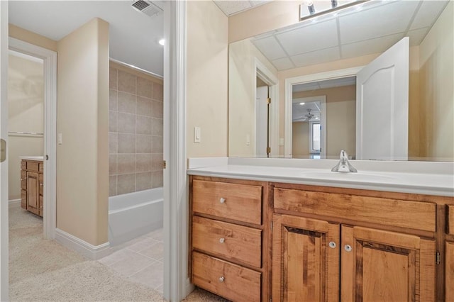 full bath featuring tile patterned flooring, a paneled ceiling, vanity, visible vents, and baseboards