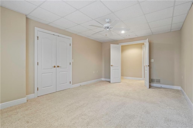 interior space with visible vents, light carpet, baseboards, and a drop ceiling