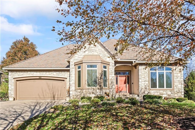 view of front of house featuring stone siding, driveway, and an attached garage