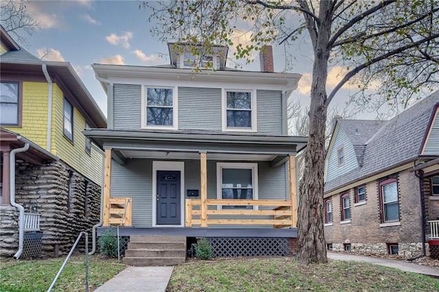 traditional style home featuring covered porch and a chimney