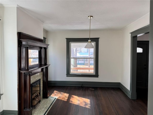 unfurnished dining area with a textured ceiling, dark wood-style flooring, a fireplace, and baseboards