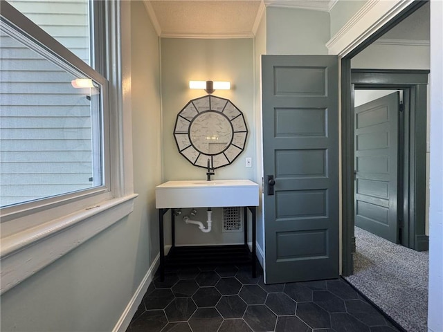 bathroom with tile patterned flooring, crown molding, and baseboards