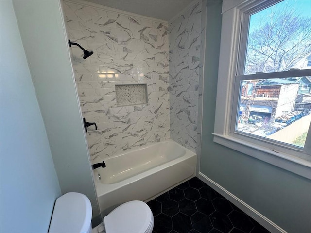 full bath featuring tile patterned flooring, baseboards, tub / shower combination, and toilet