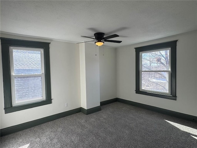 unfurnished room featuring ceiling fan, baseboards, dark colored carpet, and a textured ceiling