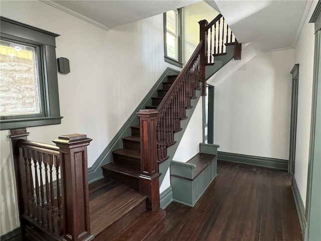 staircase featuring ornamental molding, wood finished floors, and baseboards