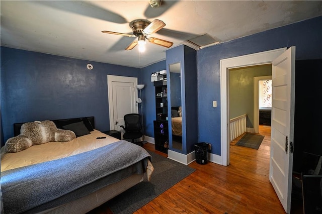 bedroom with ceiling fan, baseboards, and wood finished floors