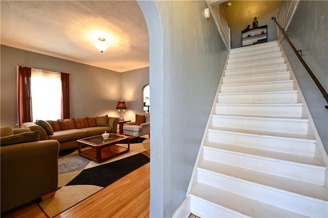 stairs with wood finished floors and arched walkways